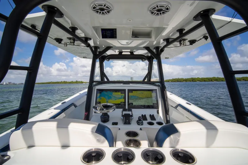 Slide: The Image of 2022 Yellowfin 39 Offshore boat interior with dual navigation screens on open water. - 16