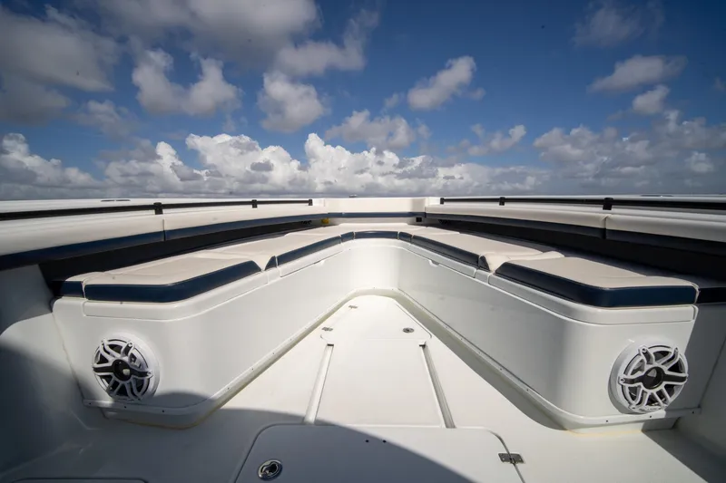 Slide: The Image of 2022 Yellowfin 39 Offshore boat interior with cushioned seating and speakers under a blue sky. - 8