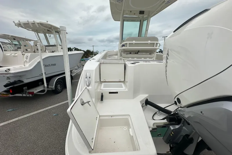 Slide: The Image of 2026 Sailfish 232 CC boat with open storage compartments and powerful outboard motor. - 29