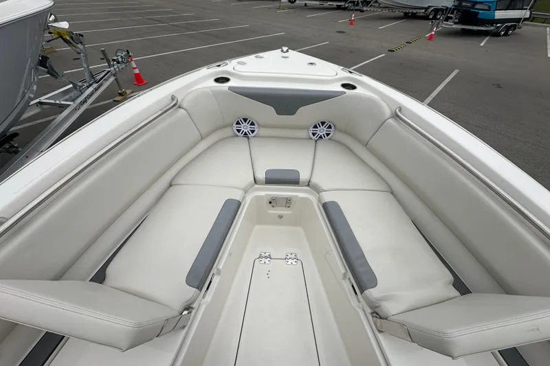 Slide: The Image of 2026 Sailfish 232 CC boat interior with cushioned seating and speakers in a parking lot. - 23
