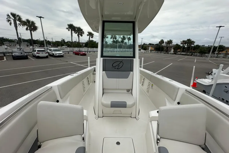 Slide: The Image of 2026 Sailfish 232 CC boat interior with seating, parked in a lot with palm trees. - 25