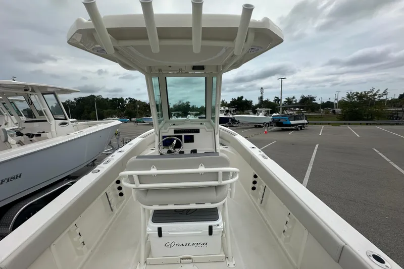 Slide: The Image of 2026 Sailfish 232 CC boat interior with helm and seating in a parking lot. - 32