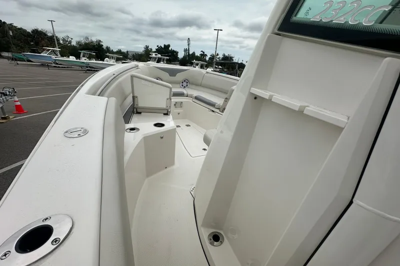 Slide: The Image of 2026 Sailfish 232 CC boat interior with seating and cup holders in a parking lot. - 18