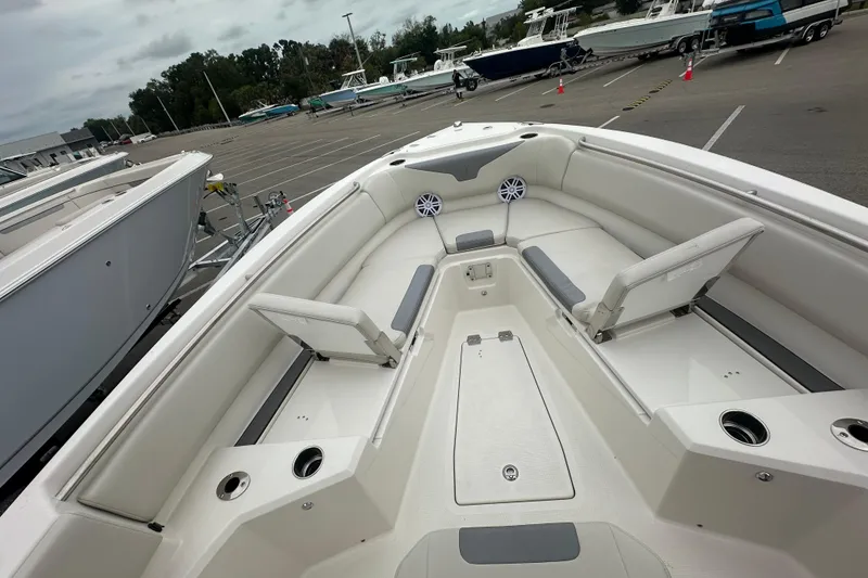 Slide: The Image of 2026 Sailfish 232 CC boat interior with seating and cup holders in a marina setting. - 22