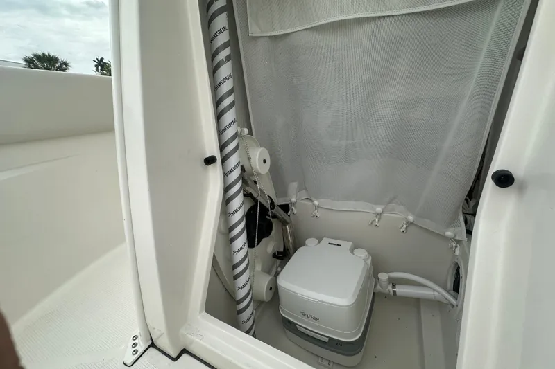 Slide: The Image of 2026 Sailfish 232 CC boat interior with portable toilet and privacy curtain. - 26