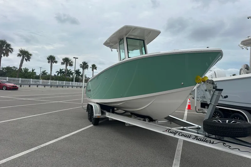 Slide: The Image of 2026 Sailfish 232 CC boat on trailer in parking lot with palm trees. - 12