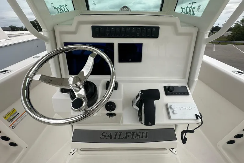 Slide: The Image of 2026 Sailfish 232 CC boat dashboard with steering wheel and navigation controls. - 31