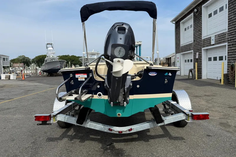 Slide: The Image of 2027 Rossiter 14 boat on trailer at marina, rear view with outboard motor. - 3