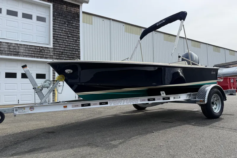 Slide: The Image of 2027 Rossiter 14 boat on Venture trailer, parked outside a garage. - 7