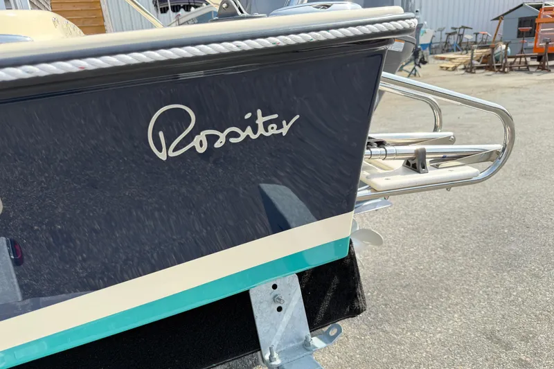 Slide: The Image of 2027 Rossiter 14 boat stern with logo, parked outdoors on a sunny day. - 31