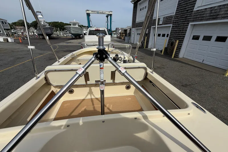 Slide: The Image of 2027 Rossiter 14 boat interior at a marina, showcasing steering and seating area. - 11