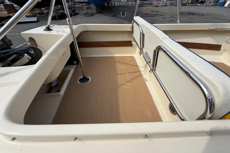 Slide: The Image of Interior of a 2027 Rossiter 14 boat, featuring beige seating and stainless steel railings. - 13