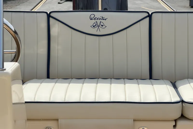 Slide: The Image of Luxurious white seating on a 2027 Rossiter 14 boat, featuring elegant stitching and logo. - 20