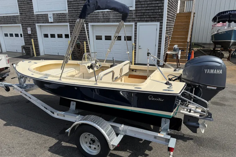 Slide: The Image of 2027 Rossiter 14 boat on trailer with Yamaha engine, parked near garages. - 8