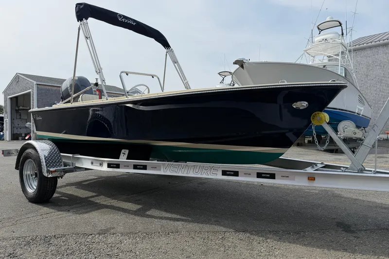 The Image of 2027 Rossiter 14 boat on trailer, parked outdoors near other boats. - 0