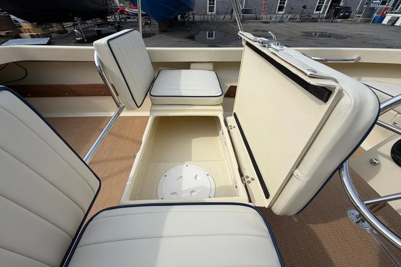 Slide: The Image of 2027 Rossiter 14 boat interior with open storage compartment and cushioned seating. - 16