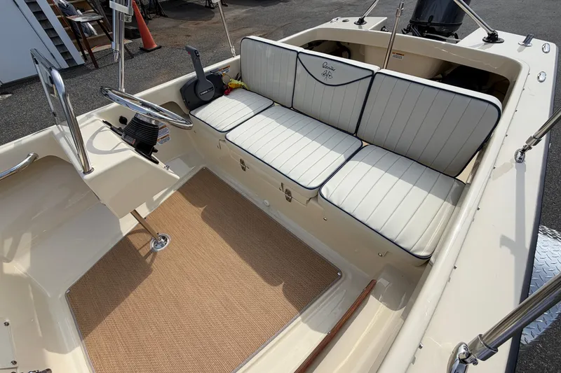 Slide: The Image of 2027 Rossiter 14 boat interior with white cushioned seating and steering wheel. - 17