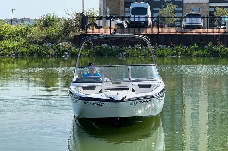 Slide: The Image of 2018 Yamaha AR210 boat on calm water near a dock. - 6