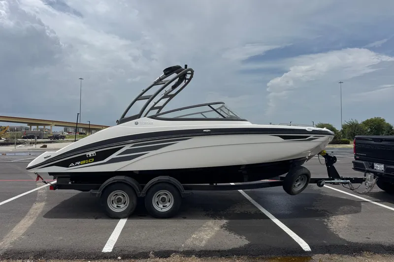 Slide: The Image of 2018 Yamaha Boats AR210 on trailer in parking lot under cloudy sky. - 11