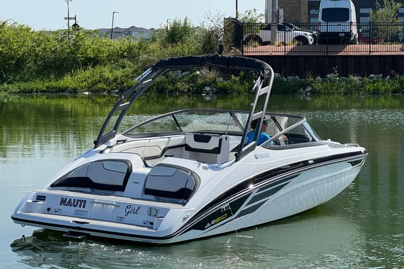 Slide: The Image of 2018 Yamaha AR210 boat cruising on a calm lake with lush greenery in the background. - 3