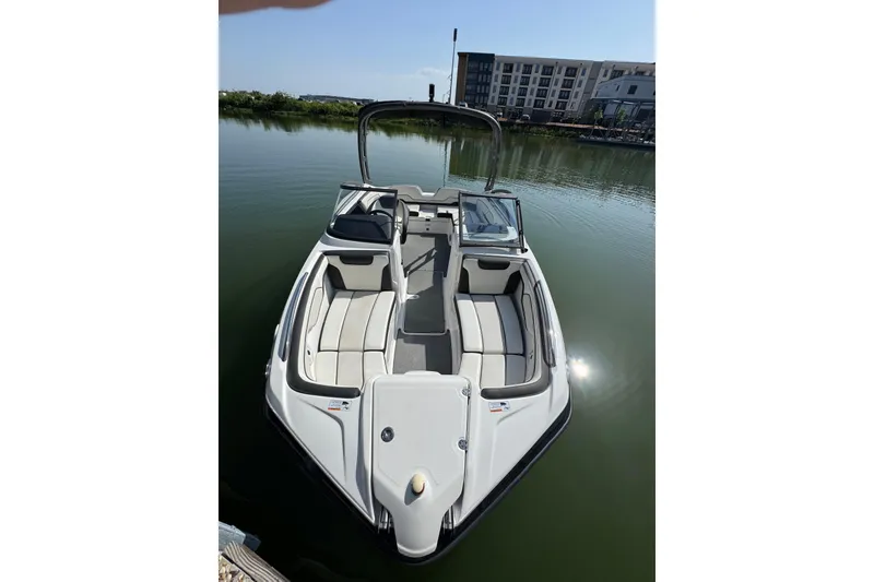 Slide: The Image of 2018 Yamaha Boats AR210 on calm water, featuring sleek design and spacious seating. - 8