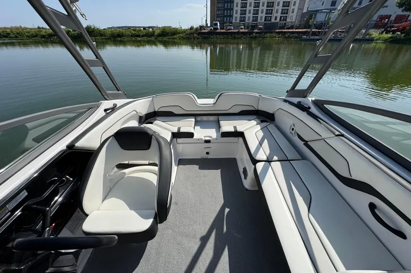 Slide: The Image of 2018 Yamaha Boats AR210 interior with sleek seating, steering wheel, and water view. - 15