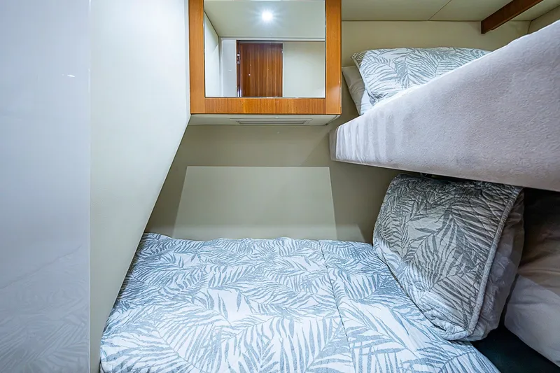 Slide: The Image of Cozy cabin interior of 2009 Riviera 58 Flybridge yacht with patterned bedding and wooden accents. - 40