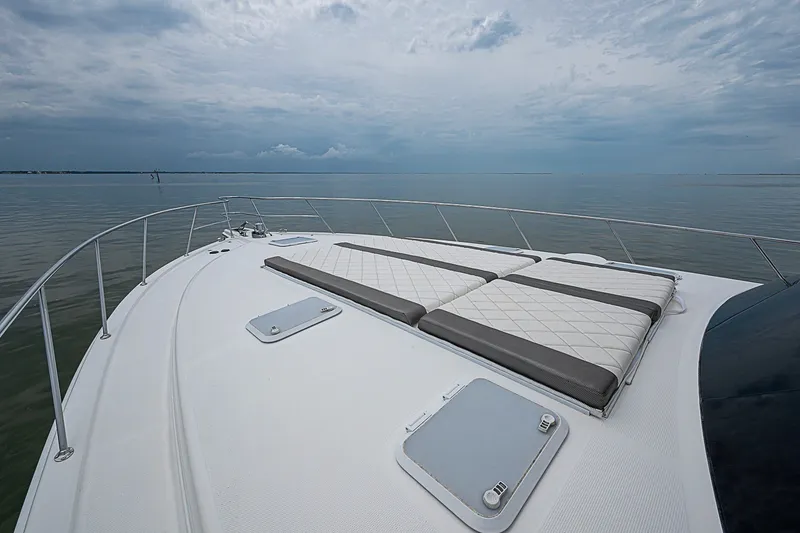 Slide: The Image of 2009 Riviera 58 Flybridge yacht deck with sun loungers on calm sea. - 88
