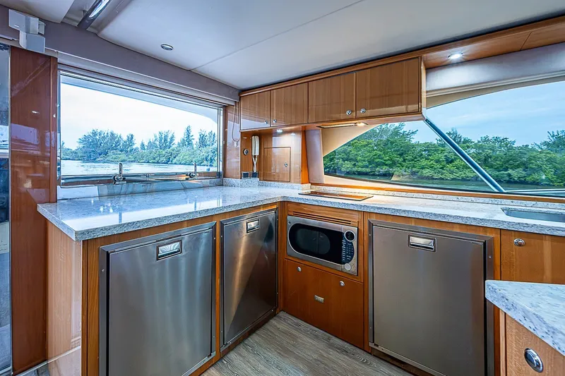 Slide: The Image of Luxurious kitchen interior of 2009 Riviera 58 Flybridge yacht with modern appliances and scenic view. - 18