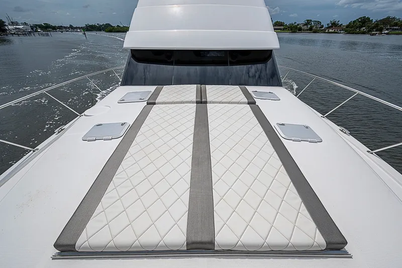 Slide: The Image of 2009 Riviera 58 Flybridge yacht with cushioned sunbathing area on deck. - 84