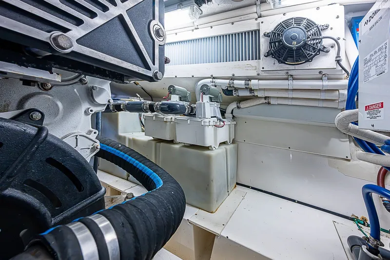 Slide: The Image of Engine room of 2009 Riviera 58 Flybridge yacht, showcasing mechanical components and piping. - 54