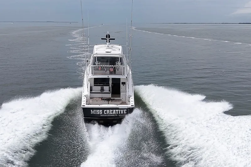 Slide: The Image of 2009 Riviera 58 Flybridge yacht cruising on open water, rear view. - 94