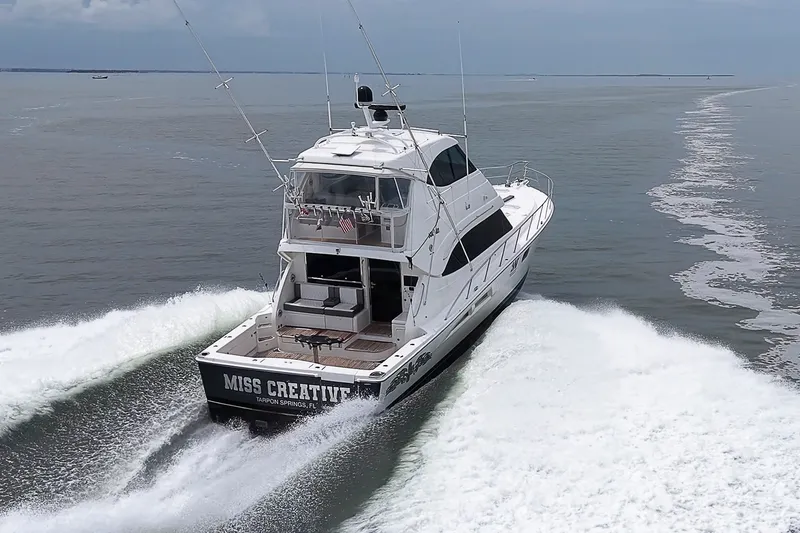 Slide: The Image of 2009 Riviera 58 Flybridge yacht cruising on open water, rear view. - 95