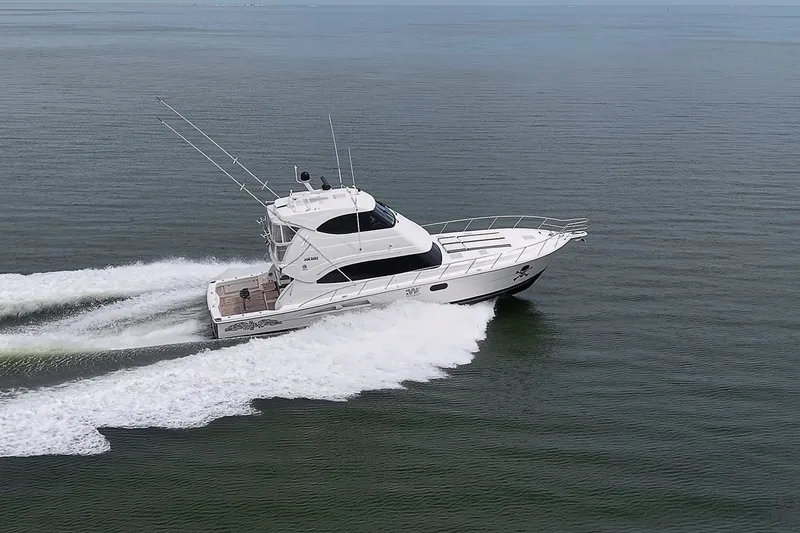 Slide: The Image of 2009 Riviera 58 Flybridge yacht cruising swiftly on open water. - 105