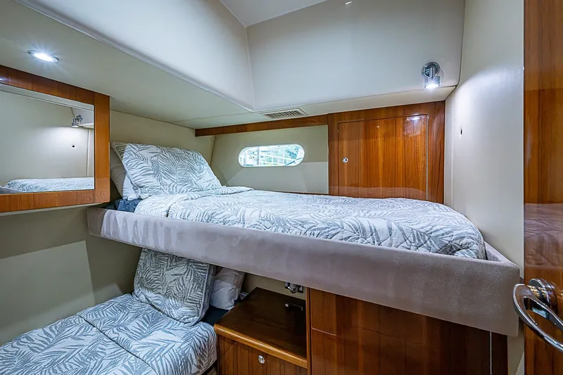 Slide: The Image of Luxurious cabin interior of 2009 Riviera 58 Flybridge yacht with bunk beds and wood accents. - 41