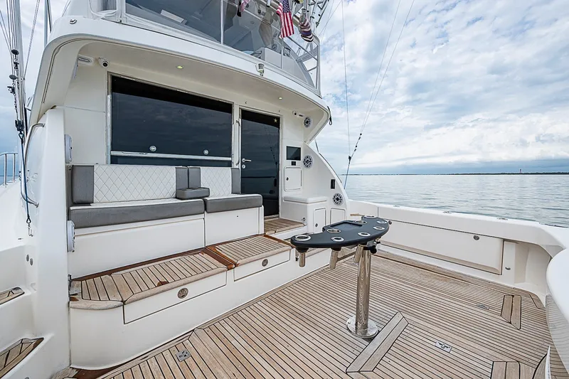 Slide: The Image of 2009 Riviera 58 Flybridge yacht deck with seating, table, and ocean view. - 79