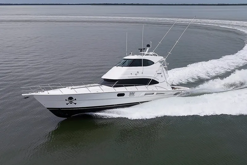 Slide: The Image of 2009 Riviera 58 Flybridge yacht cruising on open water, showcasing sleek design and performance. - 101