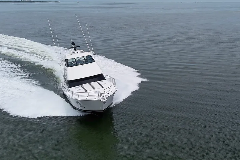 Slide: The Image of 2009 Riviera 58 Flybridge yacht cruising on open water, creating a dynamic wake. - 103