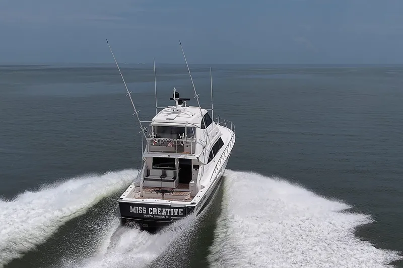 Slide: The Image of 2009 Riviera 58 Flybridge yacht cruising on open water, rear view. - 109