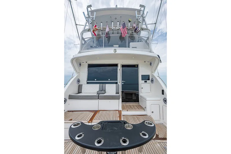 Slide: The Image of 2009 Riviera 58 Flybridge yacht with spacious deck and seating area, featuring fishing rod holders. - 76
