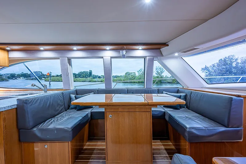 Slide: The Image of Luxurious interior of 2009 Riviera 58 Flybridge yacht with elegant seating and panoramic windows. - 19