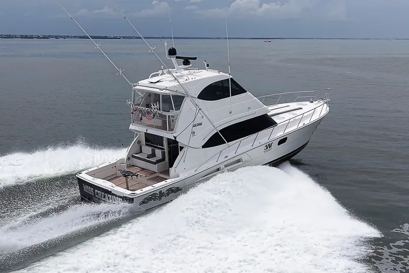 Slide: The Image of 2009 Riviera 58 Flybridge yacht cruising on open water, showcasing sleek design and powerful performance. - 99
