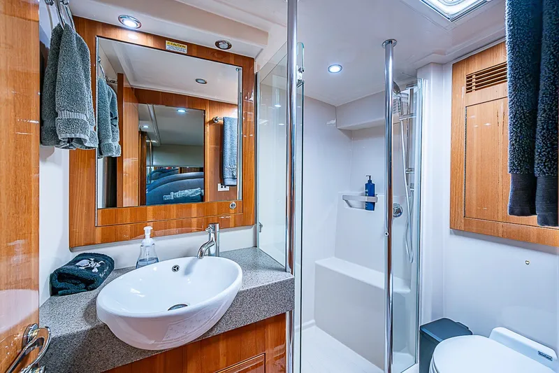 Slide: The Image of Luxurious bathroom in 2009 Riviera 58 Flybridge yacht with modern fixtures and wooden accents. - 28
