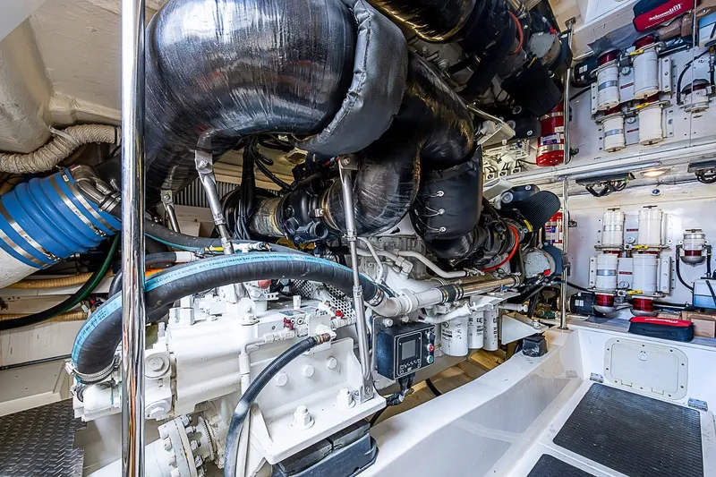 Slide: The Image of Engine room of a 2009 Riviera 58 Flybridge yacht, showcasing complex machinery and components. - 56