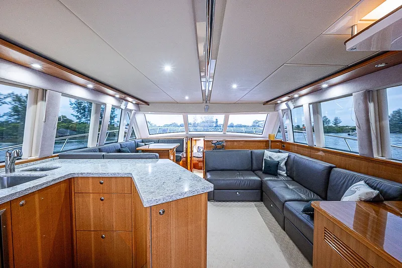 Slide: The Image of Luxurious interior of 2009 Riviera 58 Flybridge yacht with modern furnishings and panoramic windows. - 21