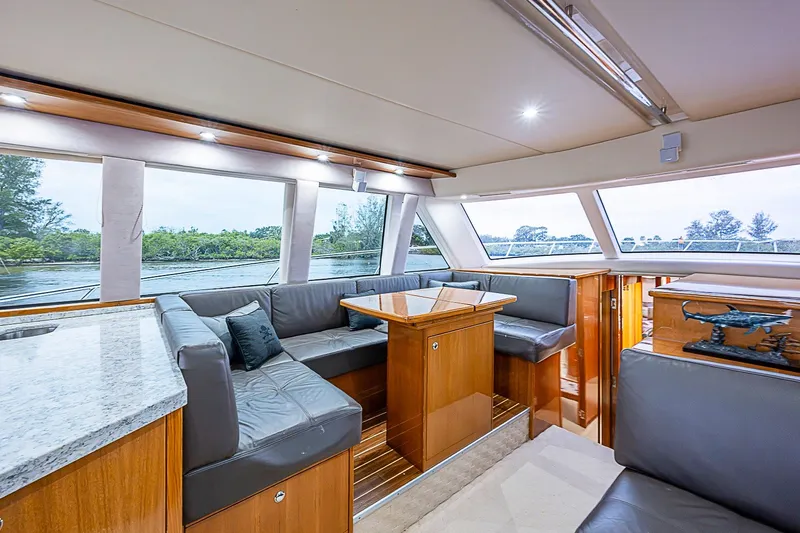 Slide: The Image of Luxurious interior of 2009 Riviera 58 Flybridge yacht with elegant seating and panoramic windows. - 20