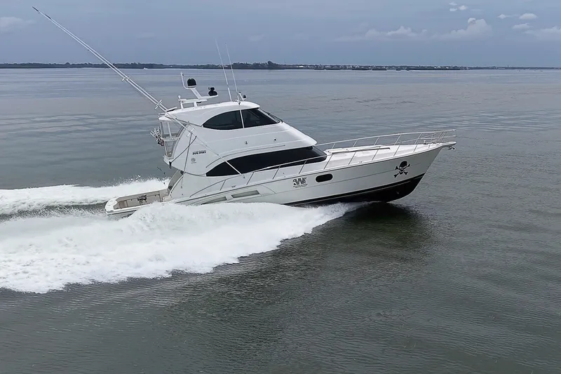 Slide: The Image of 2009 Riviera 58 Flybridge yacht cruising on calm waters. - 98