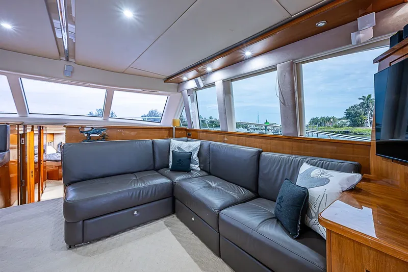 Slide: The Image of Luxurious interior of 2009 Riviera 58 Flybridge yacht with plush seating and panoramic windows. - 22