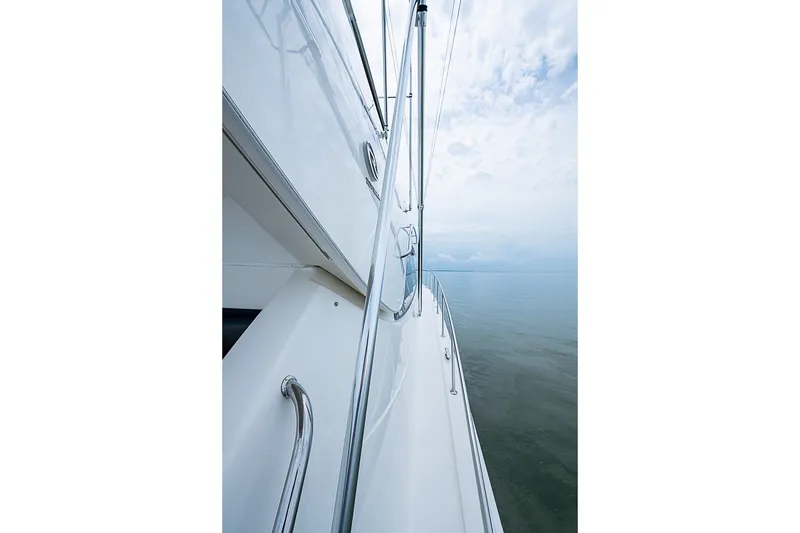 Slide: The Image of 2009 Riviera 58 Flybridge yacht side view on calm water under cloudy sky. - 91