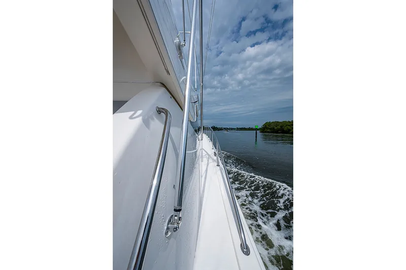 Slide: The Image of Side view of 2009 Riviera 58 Flybridge yacht cruising on a calm waterway. - 87